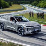 Generate a high-definition, realistic image of a new electric SUV model being tested on a closed track. The car is wrapped in camouflage patterned covering to hide its design before its official launch. The SUV has a sleek shape hinting at aerodynamic efficiency, with low ride height and large alloy wheels. The electric car is on a twisty track surrounded by greenery, and you can see engineers assessing its performance from a safe distance.